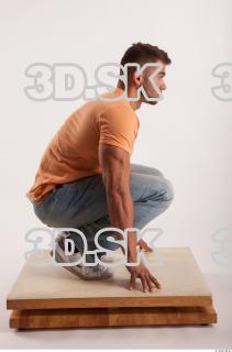 Kneeling pose orange thsirt light blue jeans of bodybuilder Harold…